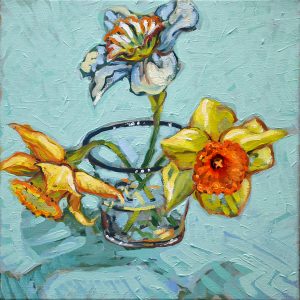 Three spring jonquils in a blue rimmed glass